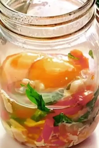 Microwaved vegetables and bacon with eggs in jar