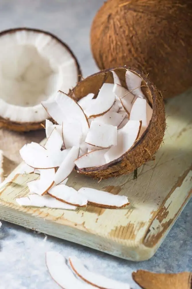 Cut coconut with coconut slithers on a cutting board